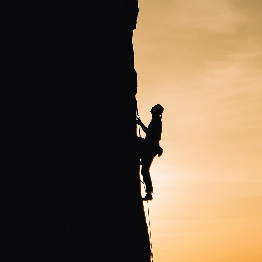 filler-hero-area-1 A woman rock climbing at sunset