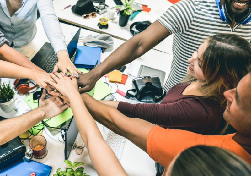 Young employee startup workers group stacking hands at urban stu Young employee startup workers group stacking hands at urban studio during entrepreneurship brainstorming project - Business concept of human resources on working time - Start up internship at office